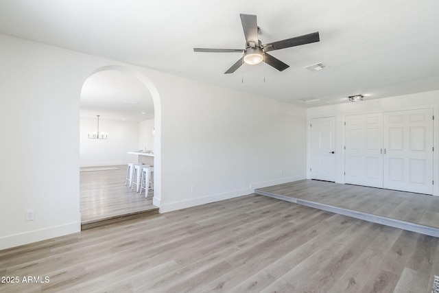 2337 E Contessa St, Mesa, AZ 85213 - unfurnished living room featuring arched walkways, a ceiling fan, and wood finished floors