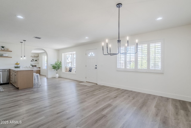 2337 E Contessa St, Mesa, AZ 85213 - unfurnished living room with arched walkways, a chandelier, light wood-style floors, and recessed lighting