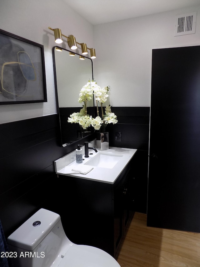 bathroom featuring toilet, large vanity, and hardwood / wood-style flooring