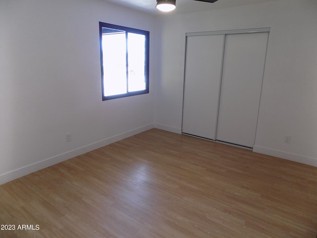 unfurnished bedroom with light wood-type flooring and a closet