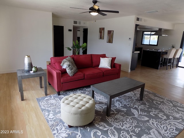 living room with ceiling fan and light wood-type flooring