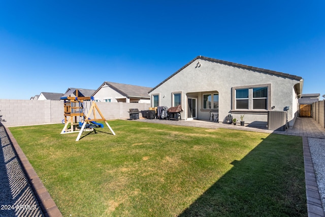 rear view of house featuring a yard, a playground, and a patio