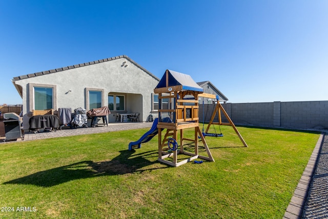 view of jungle gym featuring a patio area and a yard