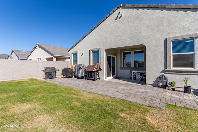 back of house featuring a yard and a patio