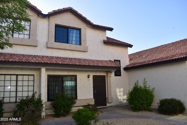 view of front of home with stucco siding and a tile roof