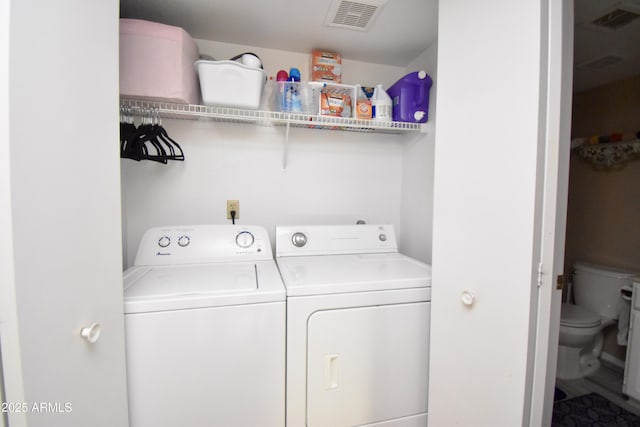 washroom featuring laundry area, washing machine and dryer, and visible vents