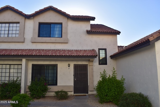 view of front of house with stucco siding and a tile roof