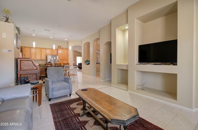 14298 W Amelia Ave, Goodyear, AZ 85395 - living room featuring arched walkways, light tile patterned floors, built in features, baseboards, and recessed lighting