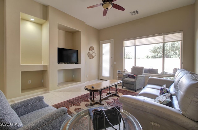 14298 W Amelia Ave, Goodyear, AZ 85395 - tiled living area featuring built in shelves, ceiling fan, and baseboards