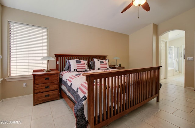 14298 W Amelia Ave, Goodyear, AZ 85395 - bedroom with arched walkways, light tile patterned floors, baseboards, vaulted ceiling, and a ceiling fan