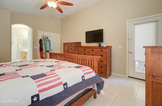 14298 W Amelia Ave, Goodyear, AZ 85395 - bedroom with arched walkways, light tile patterned floors, ceiling fan, and ensuite bathroom
