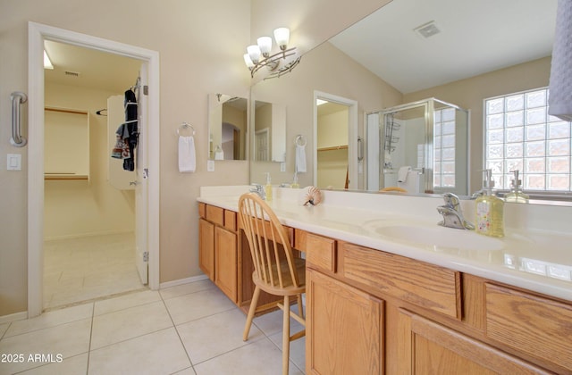14298 W Amelia Ave, Goodyear, AZ 85395 - bathroom with a stall shower, double vanity, tile patterned flooring, a spacious closet, and baseboards