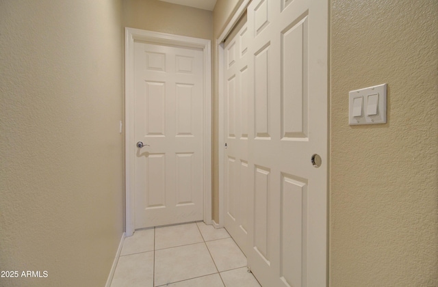 14298 W Amelia Ave, Goodyear, AZ 85395 - hall featuring a textured wall, light tile patterned floors, and baseboards