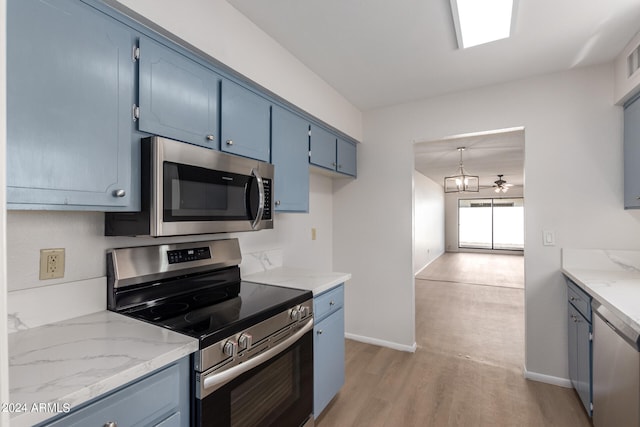 kitchen featuring light stone countertops, blue cabinetry, light hardwood / wood-style flooring, and stainless steel appliances