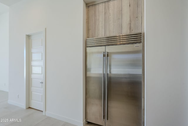 kitchen with stainless steel built in fridge and light brown cabinets