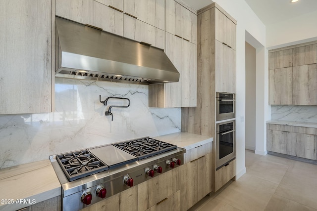 kitchen with tasteful backsplash, light brown cabinetry, and appliances with stainless steel finishes