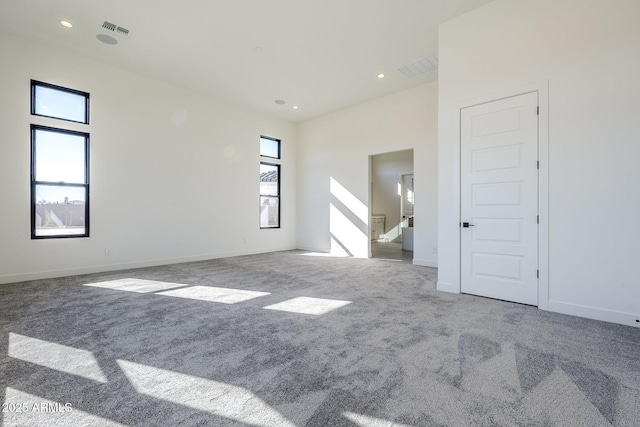 carpeted empty room with a towering ceiling