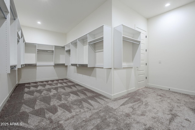 walk in closet featuring dark carpet