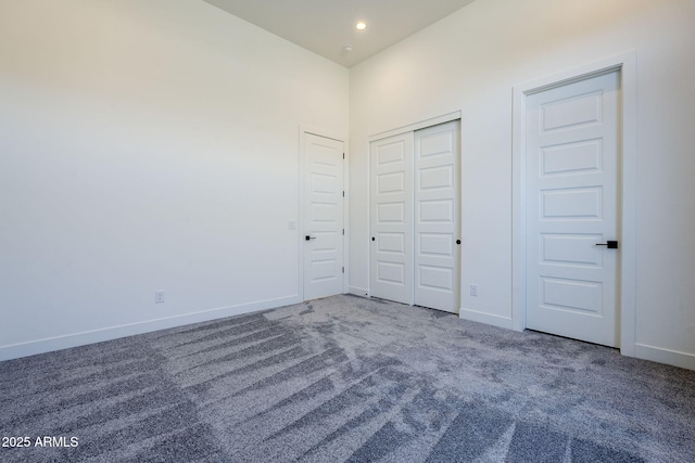 unfurnished bedroom with a high ceiling and carpet flooring