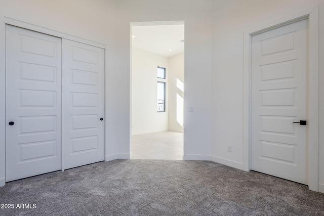 unfurnished bedroom with light carpet and a closet