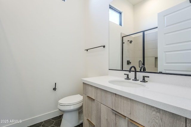 bathroom featuring a shower with door, vanity, tile patterned floors, and toilet