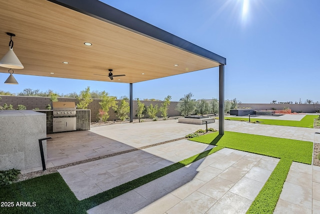 view of patio with grilling area, ceiling fan, and exterior kitchen