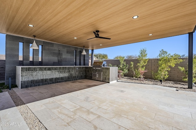 view of patio featuring area for grilling, ceiling fan, and an outdoor kitchen