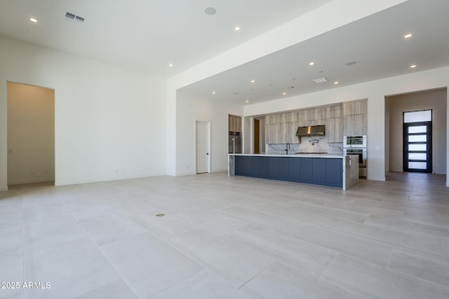 unfurnished living room featuring sink and light tile patterned floors