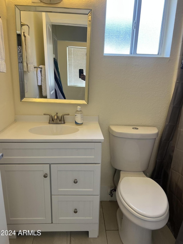 bathroom featuring a shower with shower curtain, vanity, toilet, and tile patterned flooring