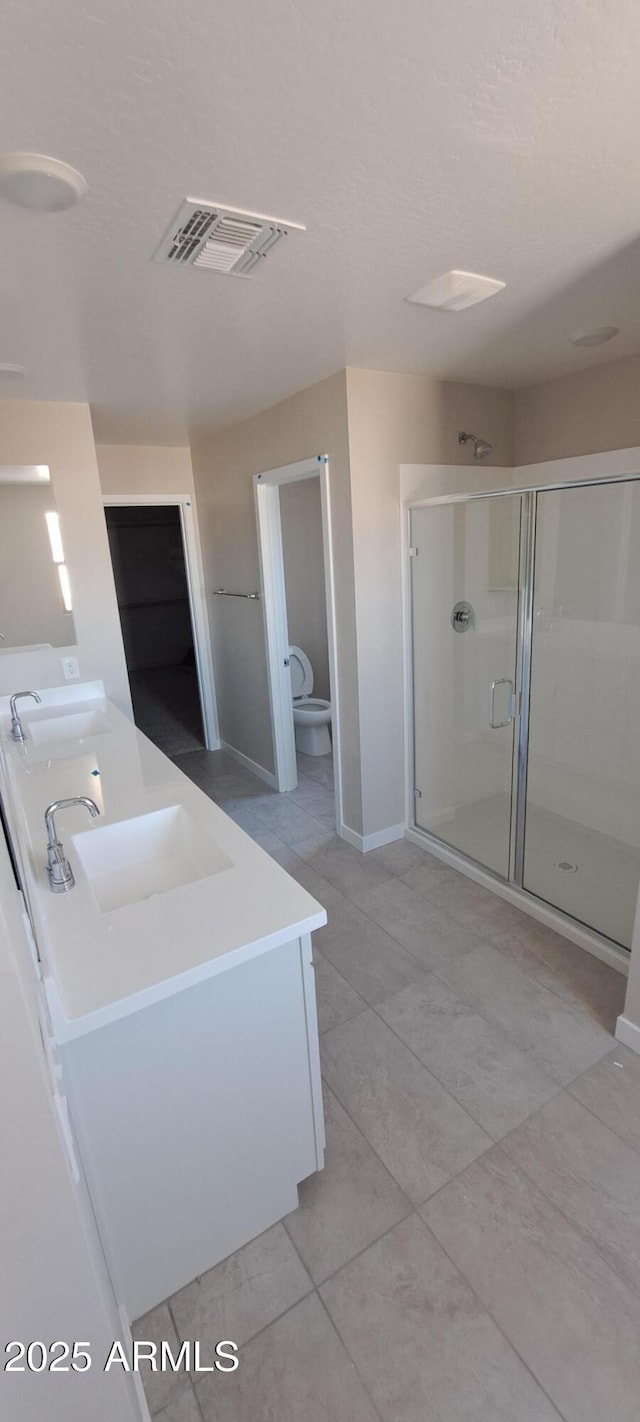 15593 S 180th Ln, Goodyear, AZ 85338 - full bath featuring double vanity, a shower stall, tile patterned flooring, and baseboards