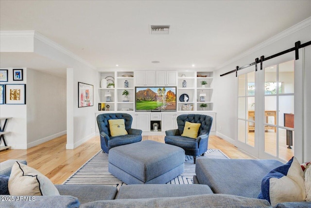 1831 E Rovey Ave, Phoenix, AZ 85016 - living room featuring a barn door, crown molding, baseboards, light wood-type flooring, and recessed lighting
