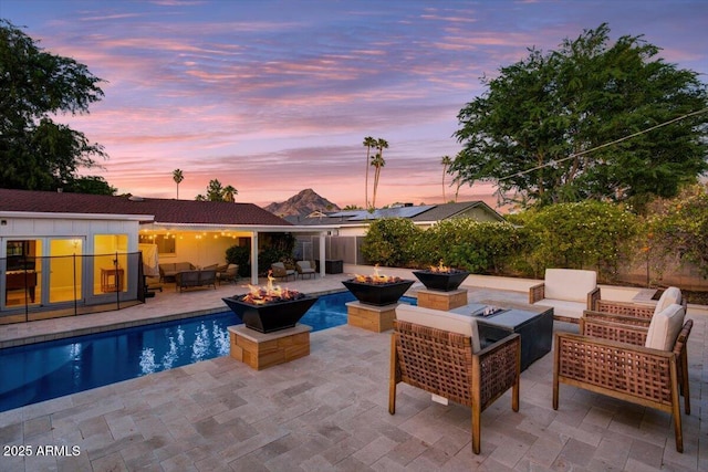 1831 E Rovey Ave, Phoenix, AZ 85016 - pool at dusk featuring an outdoor living space with a fire pit and a patio