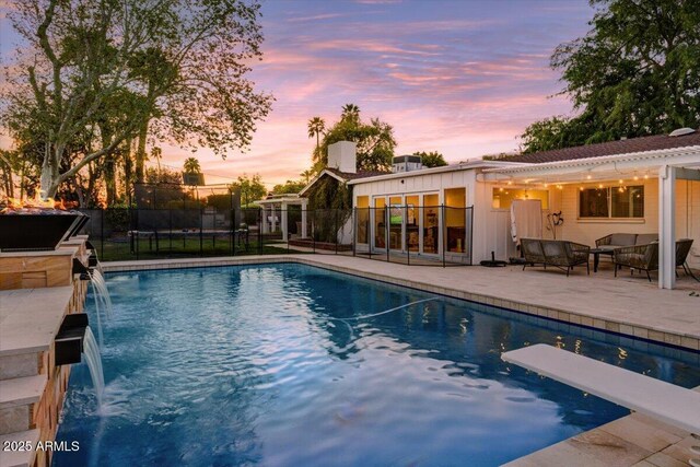 1831 E Rovey Ave, Phoenix, AZ 85016 - pool at dusk with a patio area, fence, and a diving board