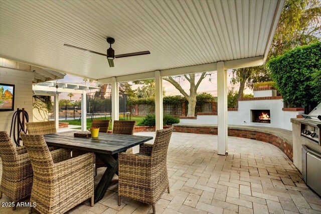 1831 E Rovey Ave, Phoenix, AZ 85016 - view of patio with a lit fireplace, a fenced backyard, outdoor dining space, and ceiling fan