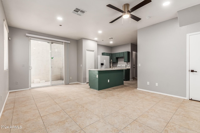 kitchen featuring ceiling fan, light tile patterned floors, sink, a kitchen island, and white refrigerator with ice dispenser