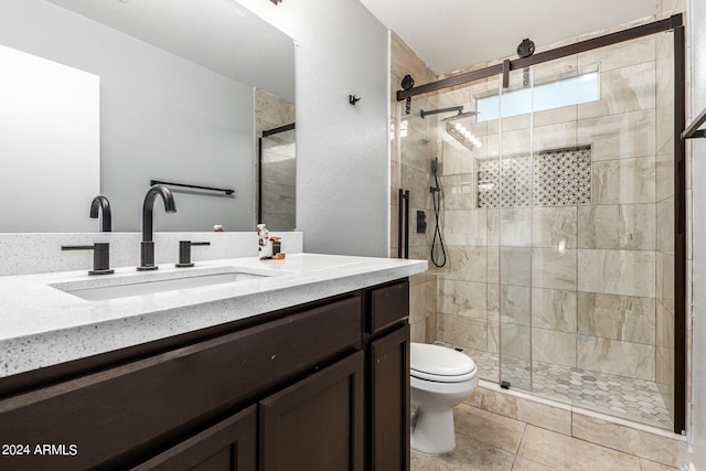 bathroom featuring tile patterned floors, an enclosed shower, vanity, and toilet