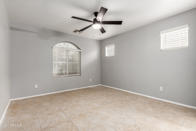 tiled empty room featuring ceiling fan