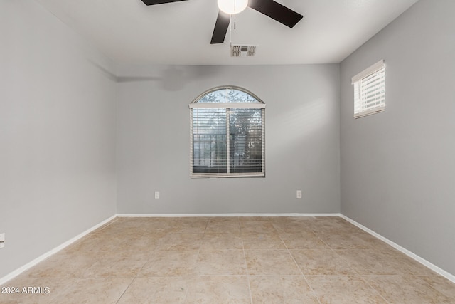 tiled spare room with plenty of natural light and ceiling fan