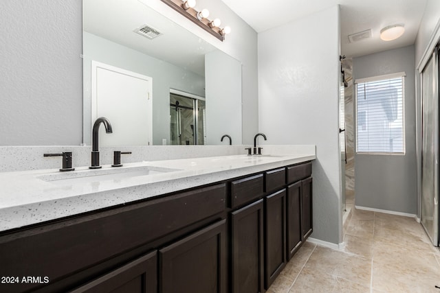 bathroom with tile patterned flooring, vanity, and a shower with shower door