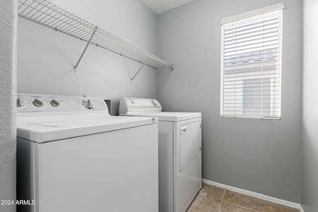 clothes washing area with light tile patterned flooring and separate washer and dryer