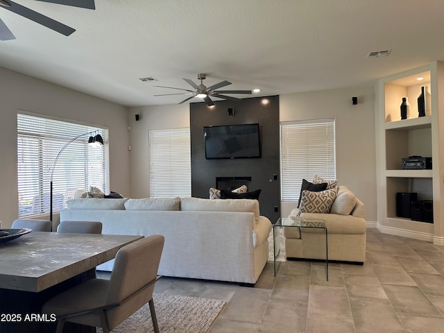 2013 E Valencia Dr, Phoenix, AZ 85042 - living room with a ceiling fan, built in features, recessed lighting, a fireplace, and baseboards