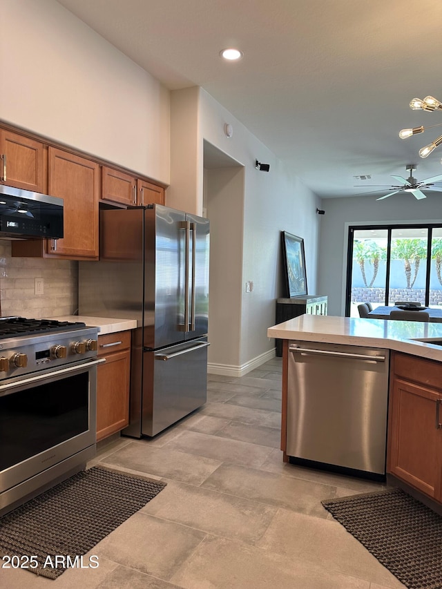 2013 E Valencia Dr, Phoenix, AZ 85042 - kitchen featuring stainless steel appliances, brown cabinets, a ceiling fan, tasteful backsplash, and light countertops