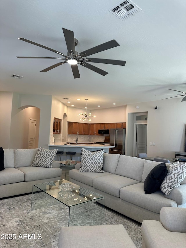 2013 E Valencia Dr, Phoenix, AZ 85042 - living room with arched walkways, a ceiling fan, a chandelier, and recessed lighting