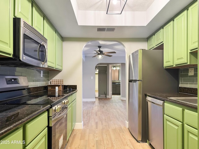 3825 E Camelback Rd Unit 182, Phoenix, AZ 85018 - kitchen with stainless steel appliances, ceiling fan, light wood-style flooring, decorative backsplash, and a raised ceiling