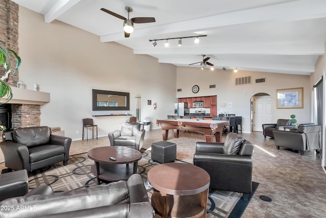 3825 E Camelback Rd Unit 182, Phoenix, AZ 85018 - living room with a ceiling fan, arched walkways, beamed ceiling, a fireplace, and high vaulted ceiling