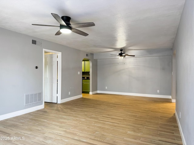 3825 E Camelback Rd Unit 182, Phoenix, AZ 85018 - spare room featuring a ceiling fan, arched walkways, and light wood finished floors