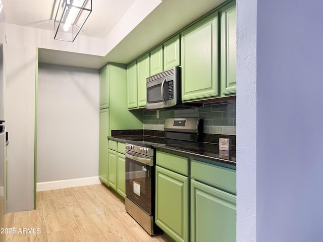 3825 E Camelback Rd Unit 182, Phoenix, AZ 85018 - kitchen with green cabinetry, appliances with stainless steel finishes, tasteful backsplash, and light wood finished floors