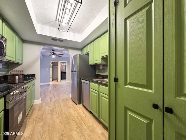 3825 E Camelback Rd Unit 182, Phoenix, AZ 85018 - kitchen with green cabinetry, appliances with stainless steel finishes, a raised ceiling, dark countertops, and ceiling fan