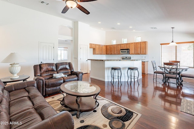 living room with hardwood / wood-style floors, high vaulted ceiling, and ceiling fan