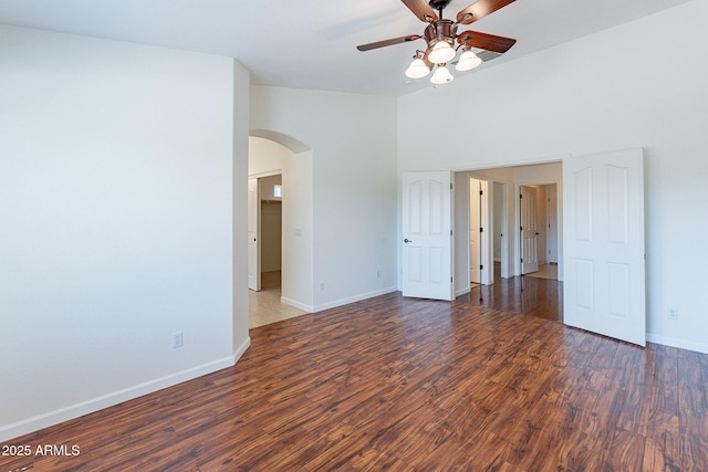 unfurnished room featuring ceiling fan, dark hardwood / wood-style floors, and high vaulted ceiling